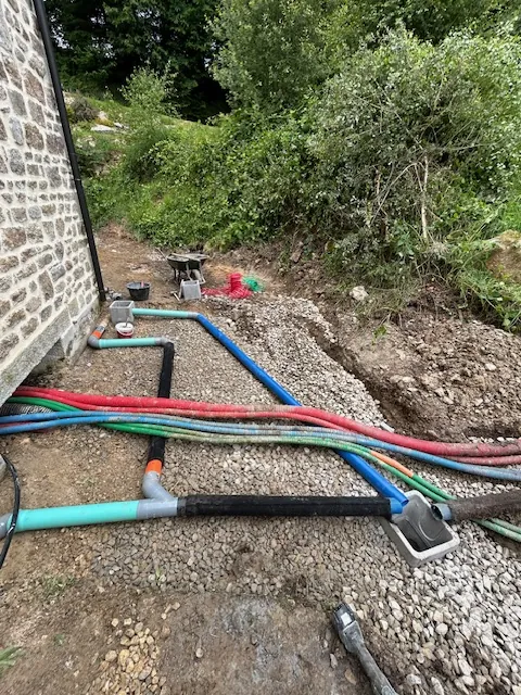 Réseaux multiples posés au pied d'un bâtiment en pierre