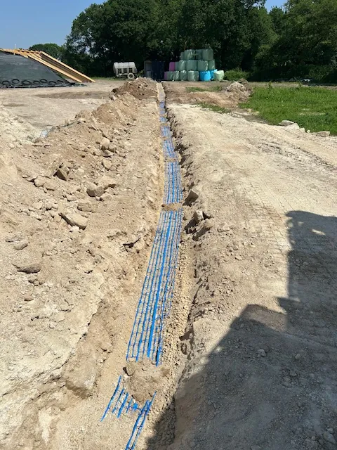 Fourreaux bleus en tranchée sur un site agricole